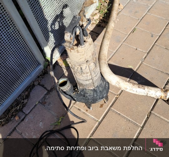 משאבה עם צינור על מדרכה